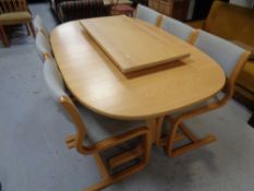 A late twentieth century pine twin pedestal extending table with leaf together with six chairs in
