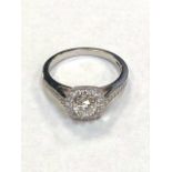 An 18ct white gold diamond halo style ring, with diamond shoulders, size M.