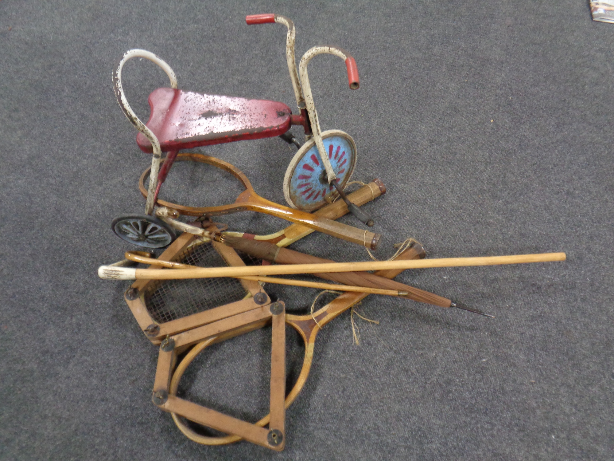 A mid 20th century tin plate child's tricycle, three vintage tennis rackets,