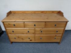A contemporary pine seven drawer chest