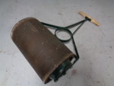 A vintage cast iron and wooden handled garden roller
