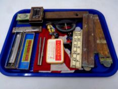 A tray of Hohner mouth organ, miniature cash box, Robertson's figures, folding wooden rules,