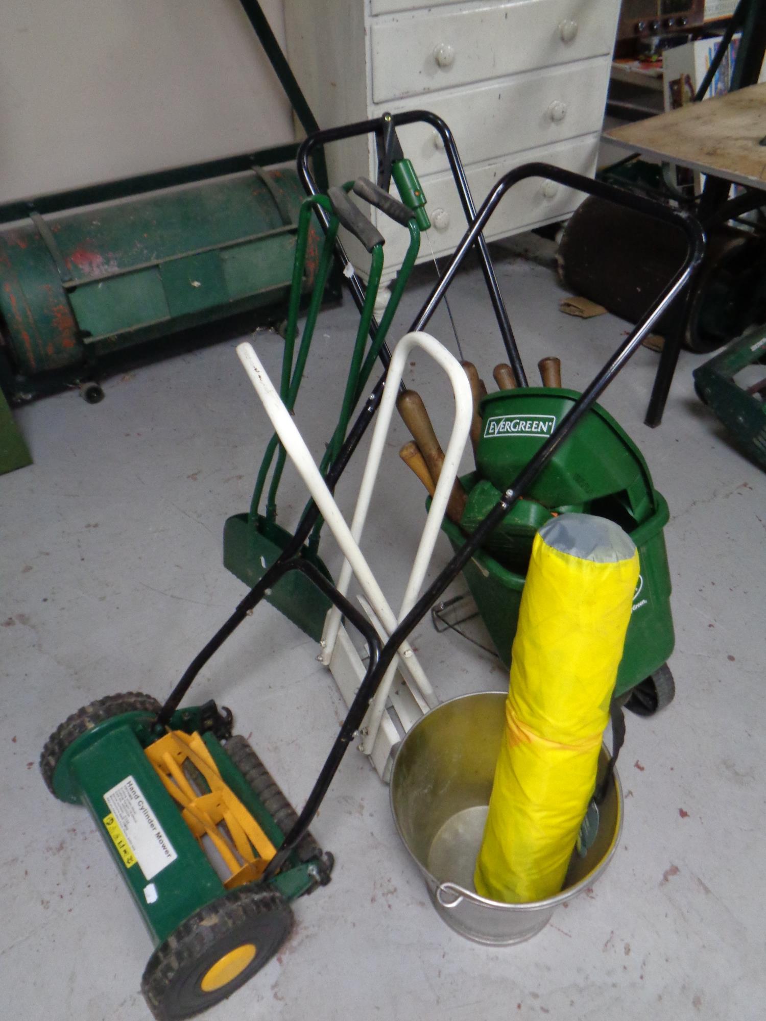 A quantity of garden tools including push mower, seed spreader, aluminium bucket,