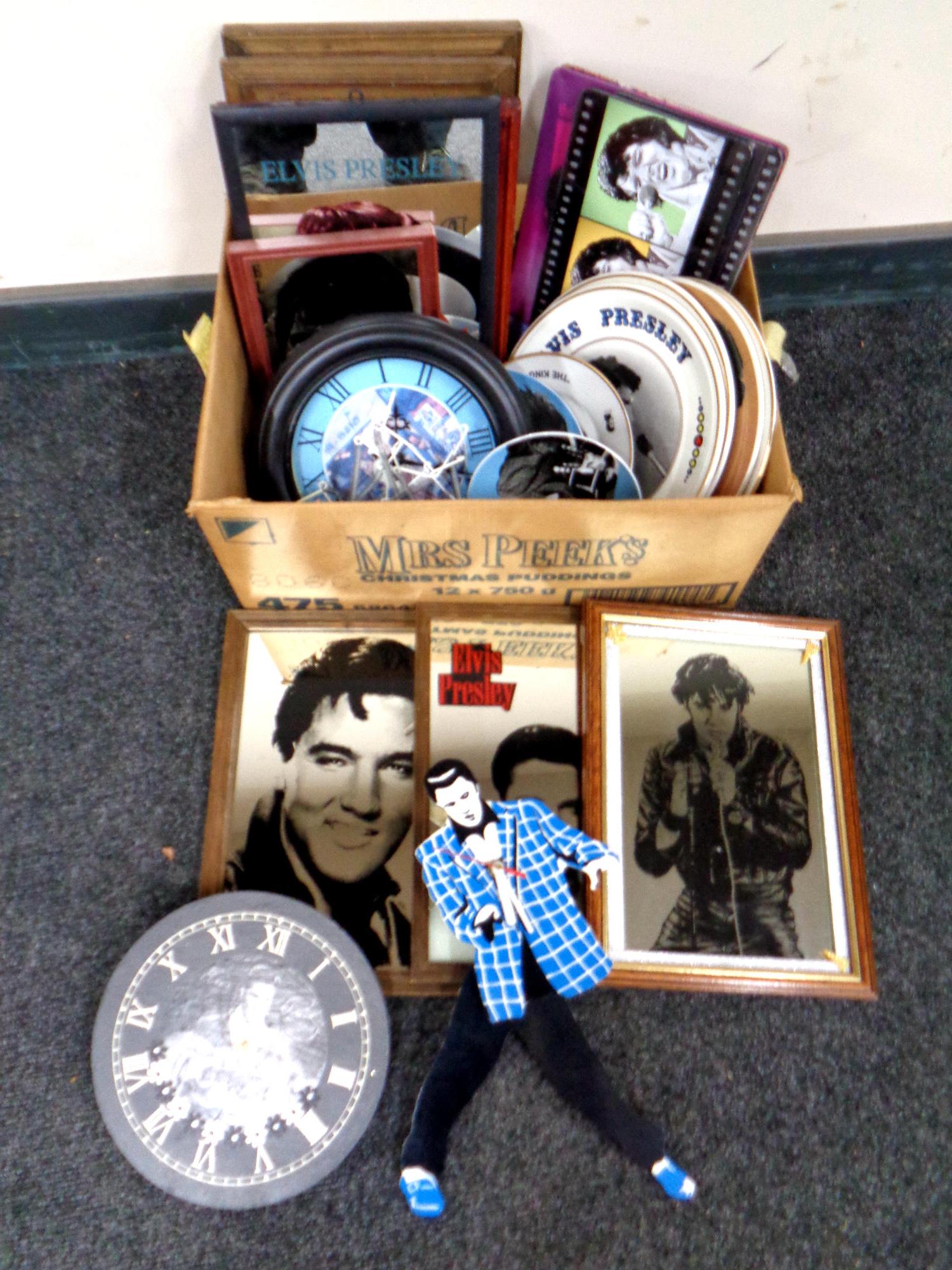 A box containing Elvis Presley memorabilia to include framed picture mirrors, wall clocks,