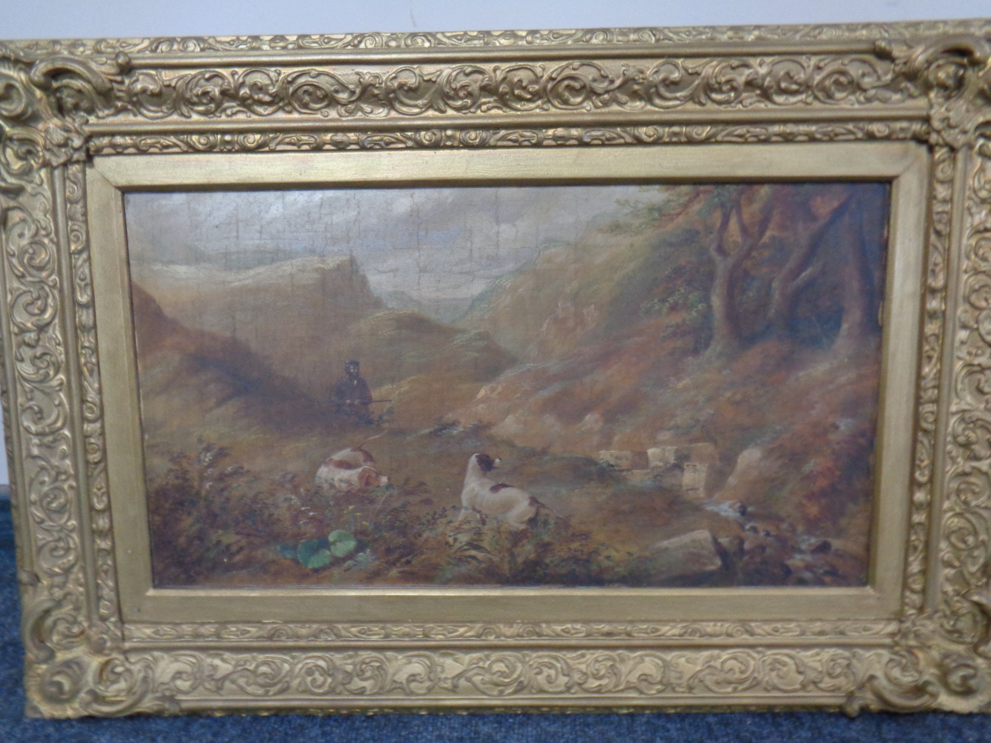 A 19th century oil on canvas, depicting a huntsman with two gun dogs, dated 1860,