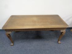 A 20th century oak coffee table on carved base with claw and ball feet