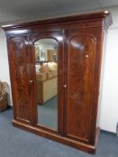 A Victorian mahogany triple door wardrobe with central mirrored door by Robsons of Newcastle