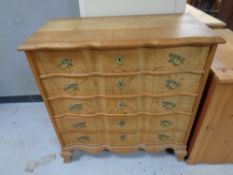 A Scandinavian blond oak serpentine fronted five drawer chest