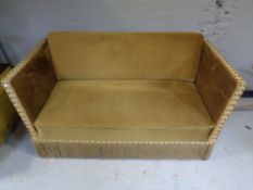 A twentieth century drop end sofa upholstered in golden fabric