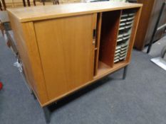 A 20th century teak shutter front office stationery cupboard