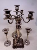 A silver plated five way table candelabra together with three further plated candlesticks