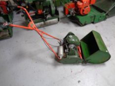 A vintage Qualcast 4 stroke Commodore petrol lawn mower with grass box and roller