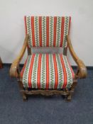 A 20th century carved oak scroll arm armchair in striped fabric