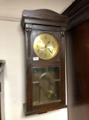 An Edwardian oak eight day wall clock with brass dial,