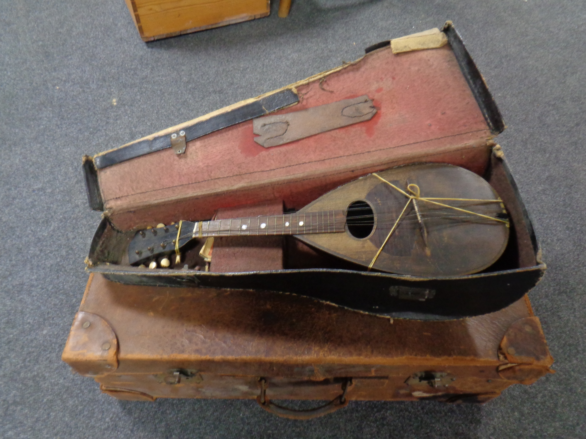 A vintage leather luggage case together with a bowl back mandolin (A/f)