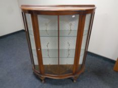 A 20th century shaped front walnut display cabinet on raised legs