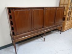 A mahogany four door sideboard fitted drawers beneath in raised legs