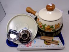 A tray of fondue set with forks and four ceramic dishes