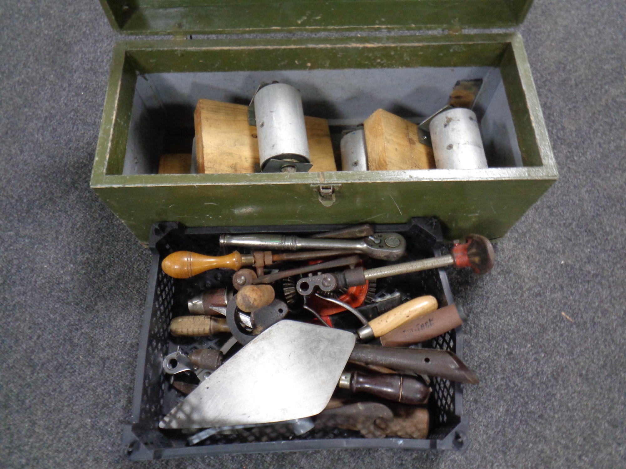 A vintage joiner's tool box containing metal rollers, basket of hand tools - trowels,