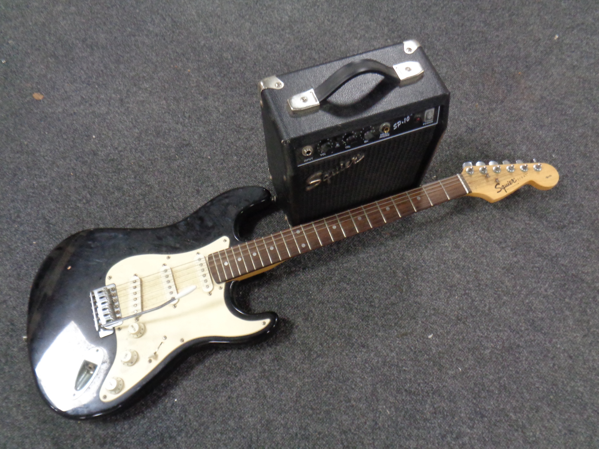 A Squier Strat by Fender electric guitar and a Squier SP.