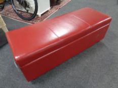 A contemporary red faux leather storage Ottoman