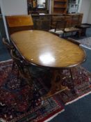 An oval oak extending refectory dining table together with a set of four beech dining chairs,