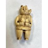 A Japanese carved netsuke modelled as a figure wearing traditional dress, height 53 mm.
