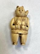 A Japanese carved netsuke modelled as a figure wearing traditional dress, height 53 mm.