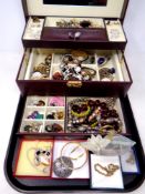 A faux leather jewellery box containing a quantity of costume jewellery, beaded necklaces, bangles,