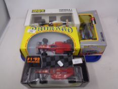 A tray of four Burago and Onyx 1:24 die cast vehicles - Ferrari F310, Formula 92, Detroit Cup,