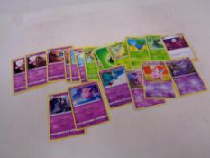 Nineteen Pokemon purple and green cards including energy and trainer cards