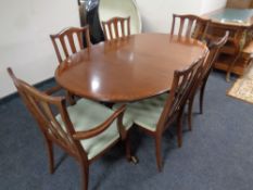 A late twentieth century G-plan oval extending dining table together with a set of six rail backed
