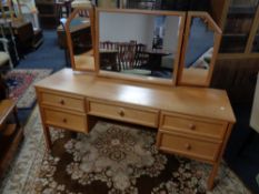 A twentieth century teak G-plan five drawer dressing table with triple mirror
