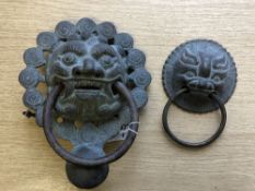 A Chinese metal ware ornate door knocker modelled as the face of a temple dog, height 21 cm,