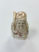 A small Japanese bone carving - Village elder holding a staff.