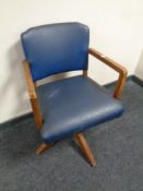 An Edwardian swivel desk armchair upholstered in blue vinyl