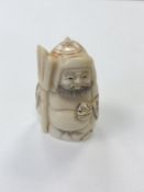 A small Japanese bone carving - Bearded man holding a fork.