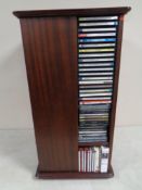 A revolving CD stand in mahogany finish together with a quantity of CD's - classical etc