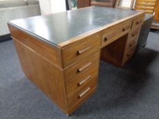 An Edwardian twin pedestal writing desk with leather inset panel fitted with nine drawers