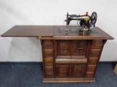 A twentieth century Singer treadle sewing machine in oak cabinet fitted with ten drawers
