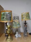 A brass oil lamp with three glass chimneys together with four contemporary table lamps,