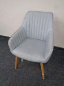 A contemporary occasional chair upholstered in grey buttoned fabric