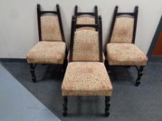 A set of four tapered backed dining chairs upholstered in coat of arms print