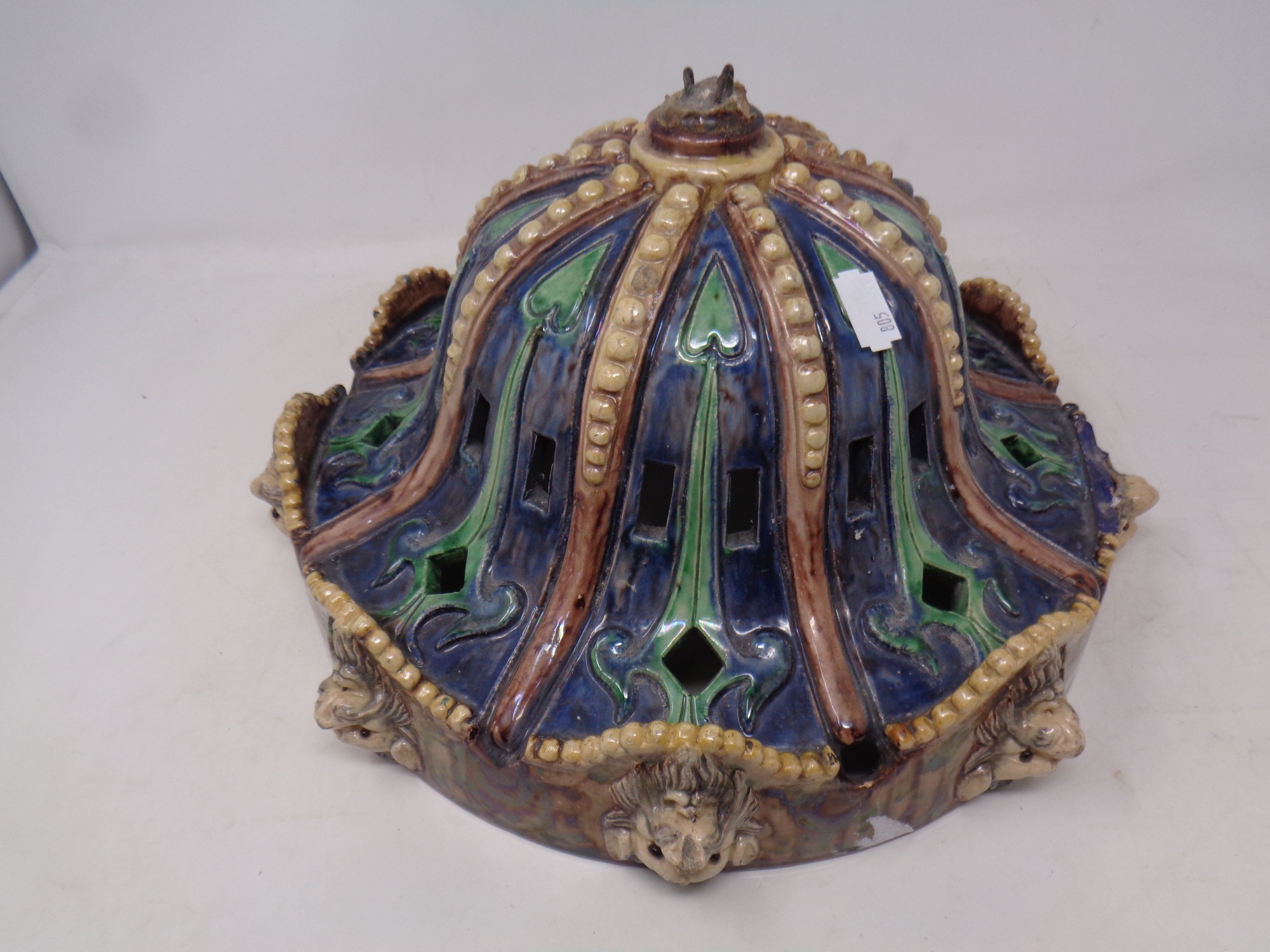 A 19th century Majolica style glazed light shade decorated with lion masks