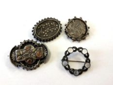 Four antique silver brooches including a moonstone example