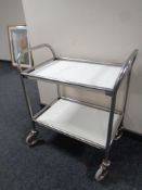 A stainless steel tubular metal two tier trolley