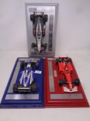 Three die cast Formula 1 cars on plinths to include Ferrari,