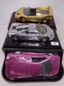 Three 1:18 scale die cast cars on plinths - Ferrari F50,