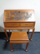 A carved Oriental style bureau fitted with two drawers together with matching stool
