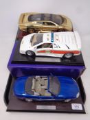 Three 1:18 scale die cast vehicles on plinths to include Jaguar XJ220,